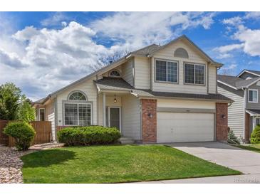 Charming two-story home featuring a well-manicured lawn, brick accents, and an attached two-car garage at 8985 Edgewood Ln, Highlands Ranch, CO 80130