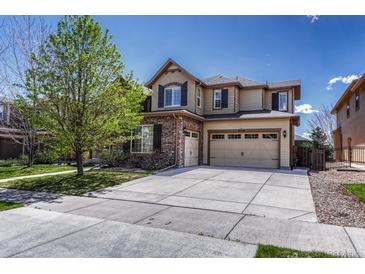 Inviting two-story home with a three-car garage, stone accents, and manicured front yard at 26566 E Peakview Dr, Aurora, CO 80016