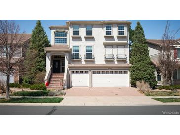 Two story stucco house with a two car garage and brick paved driveway with red brick stairs leading to the entrance at 4913 Cathay Ct, Denver, CO 80249