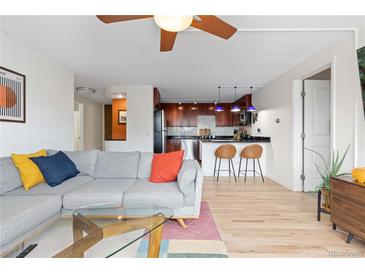 Bright living room with a gray couch, colorful pillows, and an open view to the kitchen at 1150 Vine St # 306, Denver, CO 80206