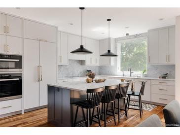 Bright kitchen with a large island, modern appliances, and stylish pendant lighting at 3130 Wyandot St, Denver, CO 80211