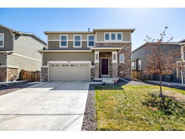 Charming two-story home with stone accents, a two-car garage, and a well-maintained front lawn at 9334 Sedalia St, Commerce City, CO 80022