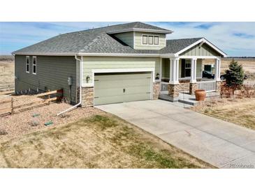Charming two-story home with a gray roof, siding, a covered porch, and a spacious two-car garage at 42425 Forest Oaks Dr, Elizabeth, CO 80107