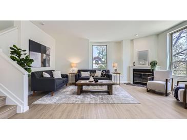 Bright living room featuring hardwood floors, modern decor, and a cozy fireplace, creating an inviting atmosphere at 2120 W 31St Ave, Denver, CO 80211