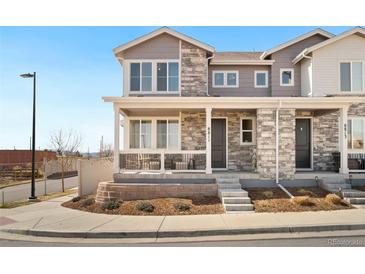 Charming two-story townhome featuring a covered front porch and stone accents for added curb appeal at 8811 Meade St, Westminster, CO 80031