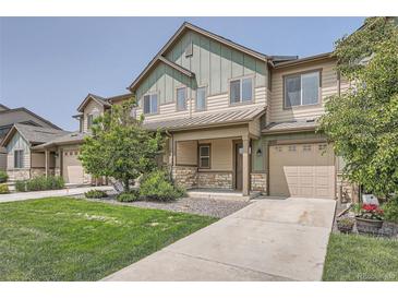 Two-story townhouse with a covered porch, a two-car garage, and a well-maintained lawn at 3573 S Lisbon Ct, Aurora, CO 80013