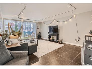 Inviting living room with neutral tones, tiled floor and modern track lighting perfect for relaxing or entertaining at 1155 Ash St # 202, Denver, CO 80220