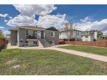 Gray brick home with a landscaped yard, walkway, and modern wooden fence at 3227 N Steele St, Denver, CO 80205