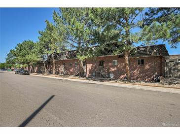 Brick building exterior with wood shake roofs, and balconies at 5401 E Warren Ave # 204, Denver, CO 80222