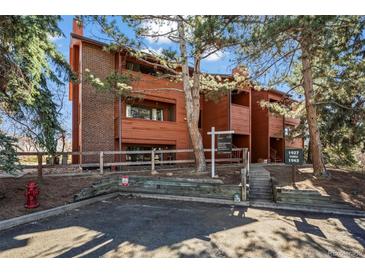 Inviting exterior of a wood-clad condo building with mature trees and well-maintained landscaping at 1931 Centennial Dr # 1931, Louisville, CO 80027