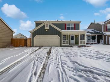 Two-story house with attached garage, snowy front yard, and a charming porch at 4578 Malta St, Denver, CO 80249