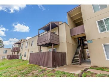 Tan apartment building featuring wood balconies and stairwell in outdoor setting at 9725 E Harvard Ave # 317, Denver, CO 80231