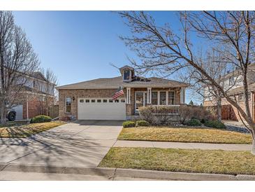 Charming brick home boasts a manicured lawn and a two-car garage at 20898 E Hamilton Ave, Aurora, CO 80013