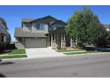 Charming two-story home featuring a two-car garage, covered porch, and well-maintained landscaping at 11811 Lewiston St, Commerce City, CO 80022