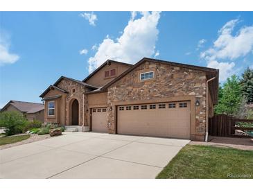 Charming home featuring a stone facade, two-car garage, and an inviting driveway at 15616 Soo Line Way, Monument, CO 80132