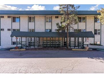 Front view of the building with a covered entrance featuring an awning and landscaped surroundings at 8826 E Florida Ave # G11, Denver, CO 80247