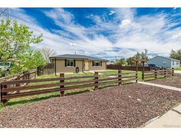 Charming single-story home featuring a brick exterior and a rustic wooden fence at 710 4Th St, Bennett, CO 80102