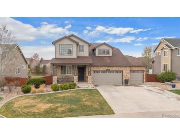 Charming two-story home with a three car garage, stone accents, landscaped yard and covered front porch at 7154 E 131St Pl, Thornton, CO 80602