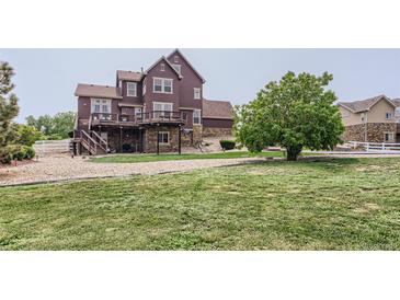 Expansive backyard features a two-story deck, lush lawn, and mature trees, ideal for outdoor gatherings at 12745 Uinta St, Brighton, CO 80602