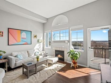 Bright living room boasts a fireplace, natural light, and outdoor access, showcasing comfortable elegance at 8199 Welby Rd # 1102, Denver, CO 80229