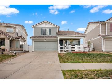 Charming two-story home with a well-manicured lawn and a quaint front porch with a white picket fence at 20414 E 55Th Pl, Denver, CO 80249