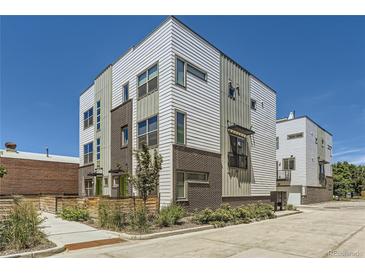 Modern townhome with mixed siding, brick accents, and large windows under a clear blue sky at 4100 E Iliff Ave # 4, Denver, CO 80222