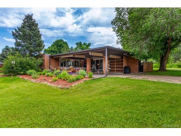 Charming home with a covered patio, beautiful landscaping, and a lush green lawn at 1016 Stearns Ave, Boulder, CO 80303
