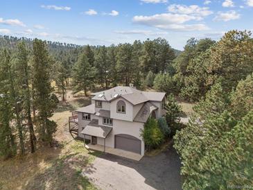 Stunning two-story home nestled among the trees with a covered entrance and attached two car garage at 30444 Ruby Ranch Rd, Evergreen, CO 80439