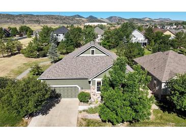 Charming single-Gathering home featuring lush landscaping, attached two car garage, and mountain views at 6699 S Robb St, Littleton, CO 80127