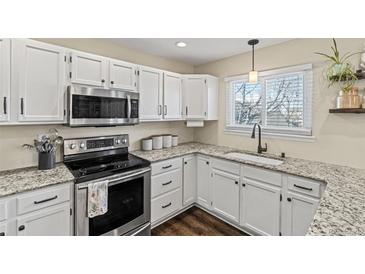 Bright kitchen features white cabinets, granite counters, stainless steel appliances, and modern fixtures at 20349 E Powers Pl, Centennial, CO 80015