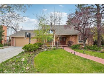 Charming brick home featuring a well-manicured lawn, brick walkway, and mature trees, perfect for curb appeal at 8424 E Otero Cir, Centennial, CO 80112