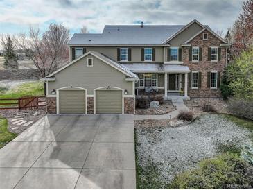 Inviting two-story home featuring a stone and siding exterior with a two car garage at 4810 Mountain Gold Run, Broomfield, CO 80023