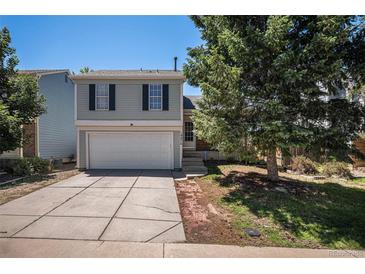 Charming two-story home featuring a two-car garage and well-maintained front yard and steps to the entry at 19876 E Brunswick Dr, Aurora, CO 80013