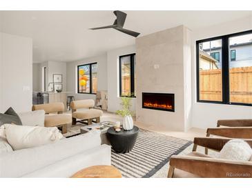 Bright and airy living room with a modern fireplace, large windows, and stylish furnishings at 2391 King St, Denver, CO 80211