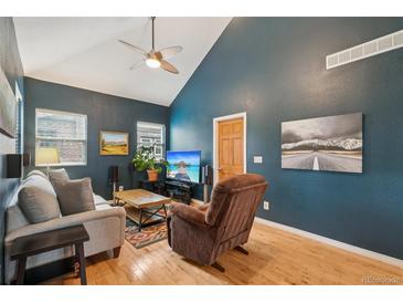 Inviting living room with vaulted ceilings, fan, wood floors, and tasteful decor for cozy relaxation at 2203 S Lincoln St, Denver, CO 80210