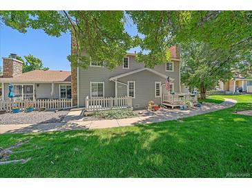 Charming home featuring a well-maintained front yard, a white picket fence, and an inviting porch at 8438 Everett Way # B, Arvada, CO 80005