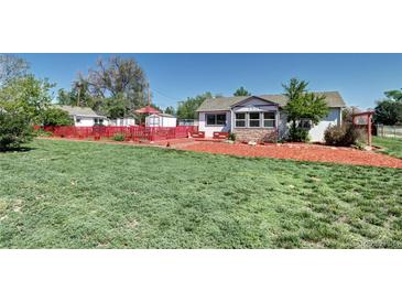 Charming home featuring a well-maintained lawn, cozy red patio, and easy-to-care landscaping at 2401 W Jewell Ave, Denver, CO 80219