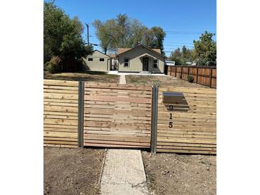 Charming home featuring a modern horizontal wood fence with metal accents and visible street address at 915 N Irving St, Denver, CO 80204