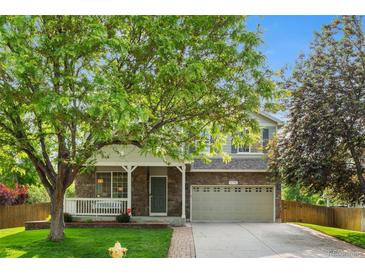 Charming two-story home featuring a stone facade, covered porch, and well-maintained front lawn and a two car garage at 14794 Vine St, Thornton, CO 80602