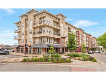 Beautiful exterior view of a multi-story condo building with retail space, lush landscaping, and outdoor seating at 10111 Inverness Main St # 301, Englewood, CO 80112