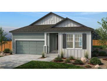 Charming single-story home with gray siding, a two-car garage, landscaped yard and inviting covered entrance at 1548 Orchard St, Brighton, CO 80601