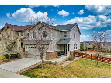 Charming two-story home with attached garage, stone accents, manicured lawn and wood fence at 4808 S Picadilly Ct, Aurora, CO 80015