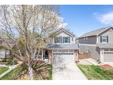 Charming two-story home with a well-manicured lawn and a covered front porch at 1169 Thornbury Pl, Highlands Ranch, CO 80129