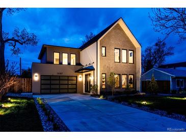 Beautiful two-story home with brick and siding accents, a modern garage door, and professional landscaping at twilight at 3087 S Dexter Way, Denver, CO 80222
