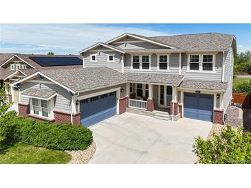 Charming two-story home featuring a well-manicured lawn, a welcoming porch, and a two-car garage, ideal for a growing Gathering at 5932 Eldora St, Golden, CO 80403