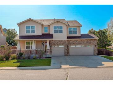 Beautiful two-story home with a three-car garage and manicured lawn on a sunny day at 15122 Fillmore Way, Thornton, CO 80602