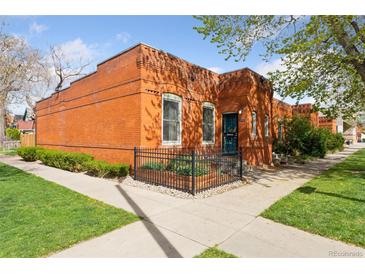 Charming brick home with landscaped front yard and black metal fence at 639 25Th St, Denver, CO 80205