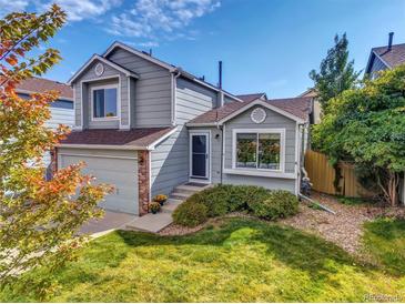 Charming two-story home with a well-manicured front yard and attached garage on a sunny day at 1462 Hyacinth Way, Superior, CO 80027
