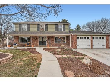 Charming two-story home with a brick facade, covered porch and well-maintained landscaping at 7823 S Locust Ct, Centennial, CO 80112