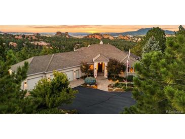 Stunning home featuring an attached three car garage and gorgeous xeriscaping with a beautiful mountain view at 6948 Fox Cir, Larkspur, CO 80118